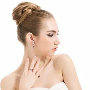 Elegante conjunto de joyas de latón con pendientes de gota rojos y anillo ovalado