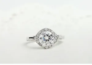 Detailopname van een luxe koperen ring met een grote ronde zirkonia in een vierkante halo