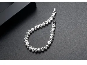 Vista detallada de una elegante pulsera plateada con eslabones de corazón y circones.