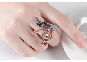 Primer plano detallado de un anillo de fénix vintage con circonitas de colores.