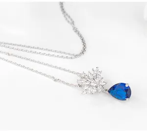 Detailopname van zilveren ketting met marquise bloem en blauwe traan zirkoon