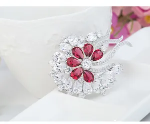 Detailed macro view of a vintage flower brooch with red and white 3A cubic zirconia