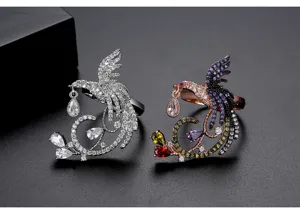 Vista detallada de anillos de fénix en plata y oro rosa con circonitas de colores.