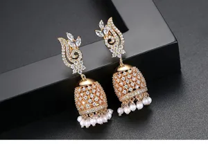 Close-up of gold Jhumka bell earrings with pavé crystals and white pearl tassels