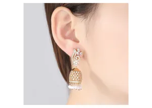 Detailed view of elegant gold-plated Jhumka bell earrings with pearls on a model's ear