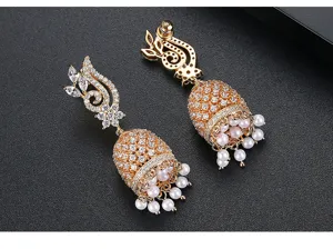 Close-up of golden Indian-style bell earrings with pearl tassels and zirconia