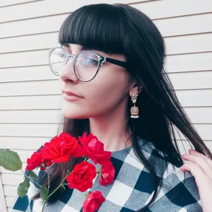 Elegant golden Indian-style pearl bell tassel earrings worn by a female model outdoors