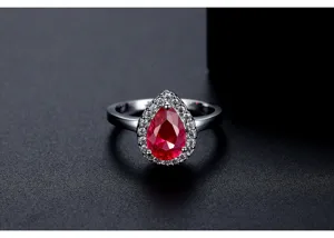 Macrodetail van peervormige rode zirkoonring met fonkelende witte halo-zetting