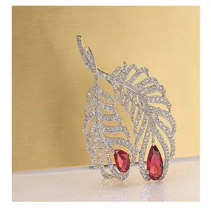 Detailed view of a vintage silver feather brooch featuring red pear-cut crystal gemstones