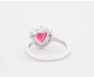 Macro-opname van een zilverkleurige hartring met een roze zirkoon en micro-pave detail