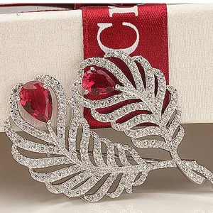 Elegant vintage feather brooch with red teardrop zircons and micro-pave crystals