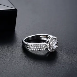 Elegante anillo plateado con gran circonita, doble halo y banda pavimentada