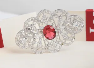 Vue détaillée d'une broche vintage de style palais avec une grande pierre rouge.