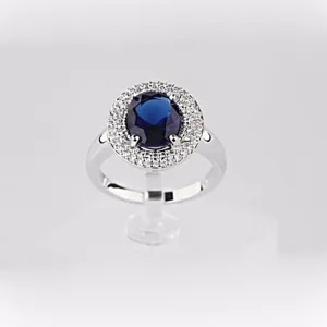 Anillo halo de lujo con circonita azul zafiro ovalada y banda de latón plateado