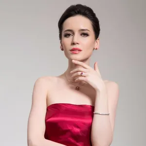 Elegant sparkling cubic zirconia tennis bracelet worn by a model in a red silk dress