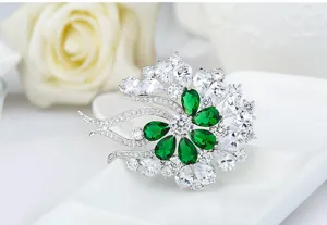 Detailed macro shot of French vintage flower brooch with green and clear cubic zirconia stones
