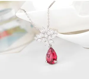 Detailopname van elegante bloemenketting met rode peervormige hanger en zirkonia