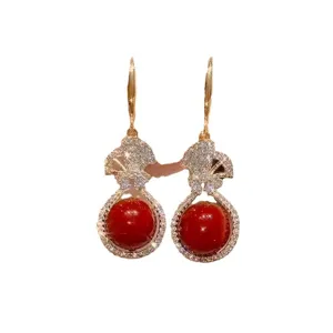 Close-up of Chinese style blessing bag earrings with red beads and sparkling crystals