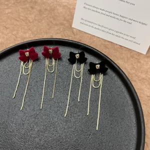 Dettaglio ravvicinato di eleganti orecchini a fiocco in velluto con lunghe nappe