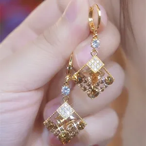 Close-up of sparkling coffee brown crystal earrings in a vintage gold-tone frame.