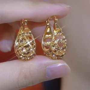 Detailed close-up of vintage gold leaf earrings encrusted with sparkling Maillard rhinestones