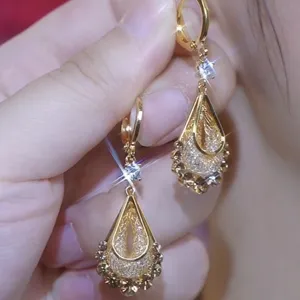 Elegant vintage gold-plated teardrop earrings with intricate filigree and sparkling crystals.