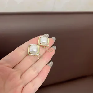 Close-up detail of vintage geometric square pearl earrings with rhinestones