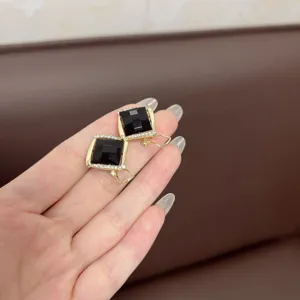 Detailed view of vintage square earrings featuring black gemstones and rhinestone halo.