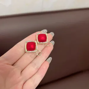 Close-up of vintage square red earrings with sparkling rhinestones in gold setting