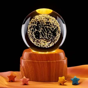 Detalle de bola de cristal de galaxia grabada en 3D con base de madera iluminada