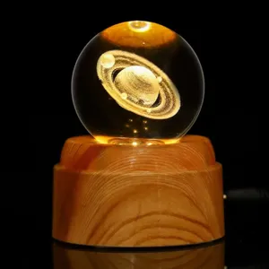 Vista detallada de una bola de cristal de Saturno grabada en 3D sobre base de madera con LED