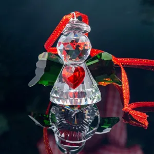 Detailed view of a sparkling faceted crystal angel ornament with a red heart and ribbon.