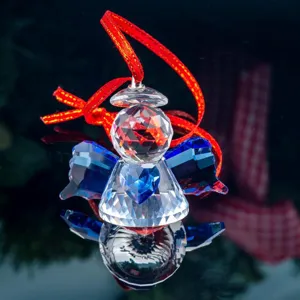 Close-up of faceted crystal angel ornament with blue heart and wings decoration