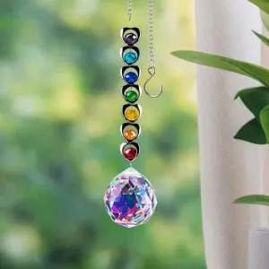 Close-up of a rainbow maker suncatcher with chakra crystals and a faceted prism ball