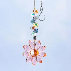 Detalle de un atrapasol de girasol de cristal con pétalos rosas y cuentas.