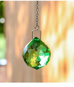 Detailansicht eines 40mm grünen facettierten Kristallprismas als Sonnenfänger mit Licht