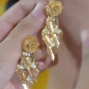Detailed view of elegant gold rose tassel earrings with sparkling rhinestones texture