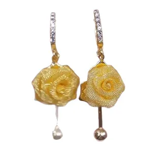Detail of elegant mesh rose earrings with sparkling rhinestones and gold finish.