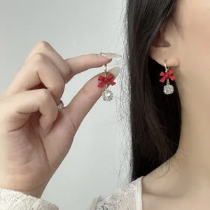 Nahaufnahme von eleganten roten Schleifenohrringen mit funkelnden Zirkonia am Modell.