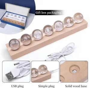 Detailed view of galaxy crystal ball night light with USB plug and solid wood base.
