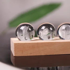 Close-up of 3D laser engraved astronaut and galaxy crystal balls on a wooden base