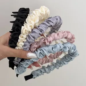 Detailed macro view of colorful satin pleated headbands with smooth shiny texture