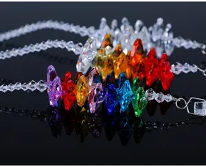 Close-up of vibrant colorful faceted K9 crystal hanging ornaments on reflective black surface