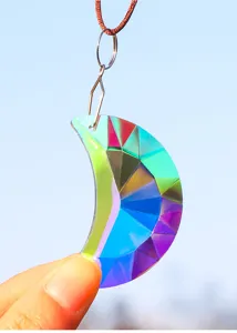 Gros plan d'un pendentif en cristal de lune irisé aux multiples facettes et reflets arc-en-ciel