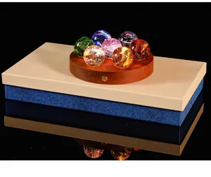 Macro shot of colorful crackled glass spheres on a circular wooden LED base gift box set