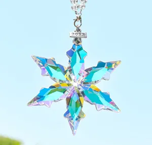 Close-up detail of a sparkling crystal snowflake car pendant with vibrant light refraction.