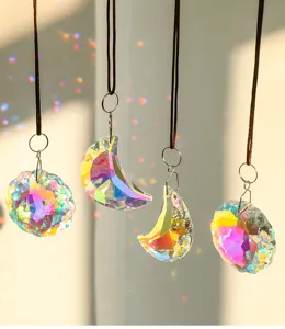 Gros plan de pendentifs en cristal irisé en forme de lune et de fleur avec reflets arc-en-ciel