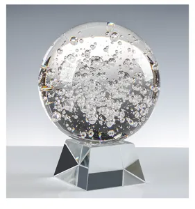 Close-up macro view of a transparent k9 crystal bubble ball with a faceted glass base