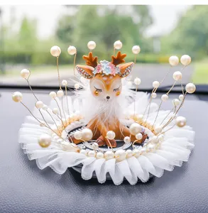 Detailed macro view of a cute fawn car ornament with pearls and lace base