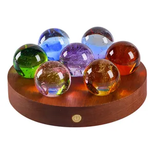 Handcrafted colorful glass spheres in a seven-star array on a light luxury wooden LED base